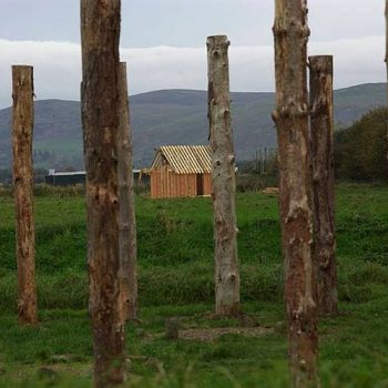 The reconstructed Dark Age Hall viewed through the henge. © Copyright ARS Ltd 2018