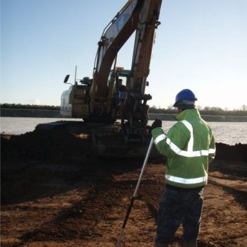 A mechanical excavator stripping the ploughsoil at Lanton Quarry. An archaeologist is observing the gravel surface as it is revealed for traces of archaeological features, ready to clean it back with a hoe. © Copyright ARS Ltd 2018