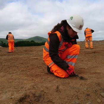 Cleaning the Neolithic house, with Yeavering Bell in the background. © Copyright ARS Ltd 2018