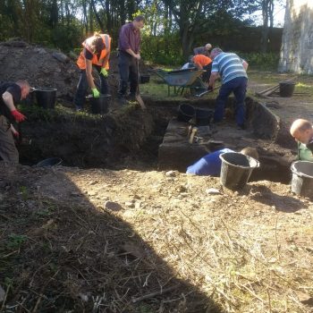 Volunteers can be seen here cleaning the newly-discovered wall foundation within the trench extension. © Copyright ARS Ltd