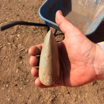 A Neolithic Group VI ground and polished axe head made from Langdale tuff found at the top of a pit fill on a gravel ridge.